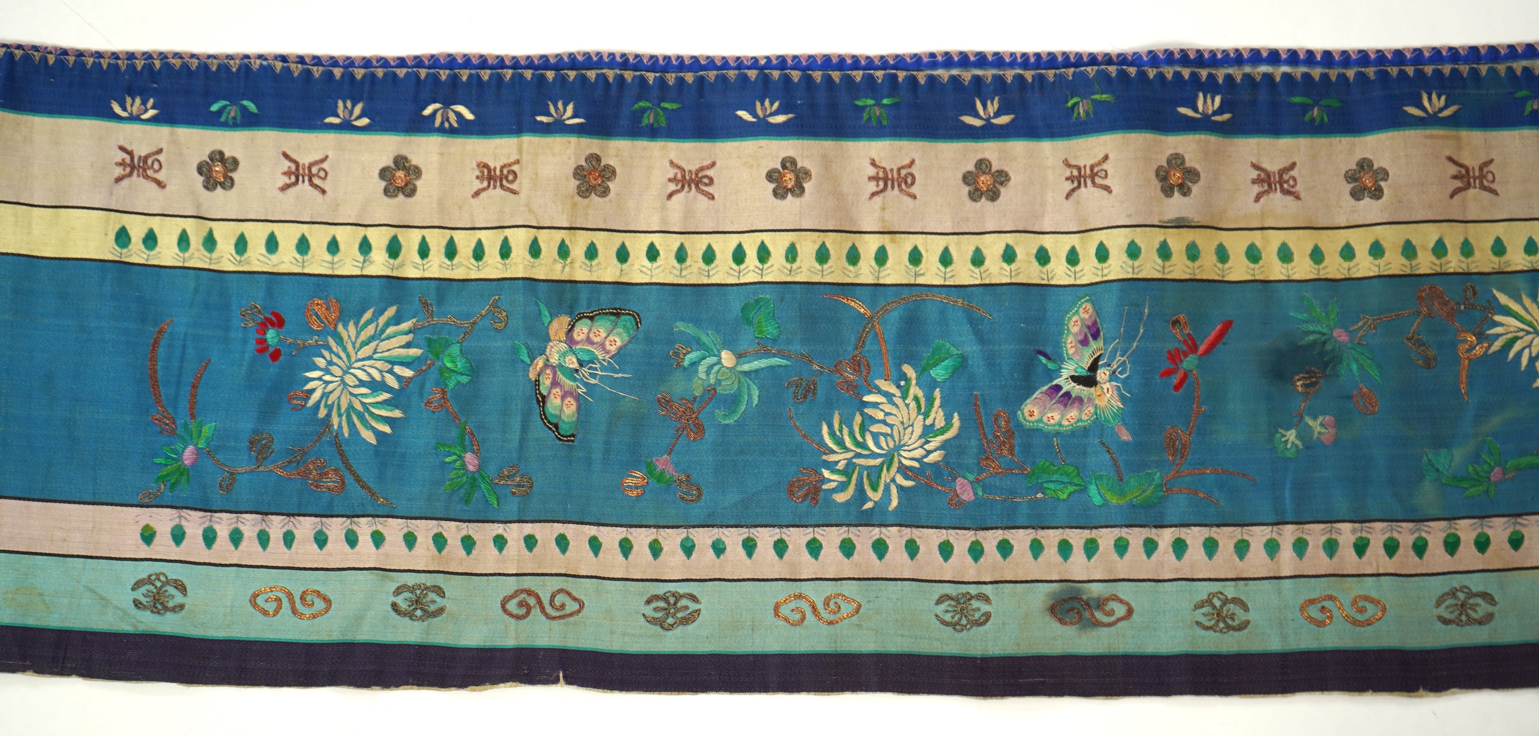 A Chinese embroidered silk panel of uncut robe borders, eleven similar sleeve panels and two other items, late Qing dynasty